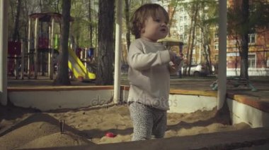 Kum havuzunda oynayan bir çocuk