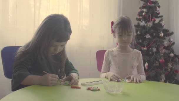 Meninas perto de árvore de natal pintura brinquedos cerâmicos — Vídeo de Stock