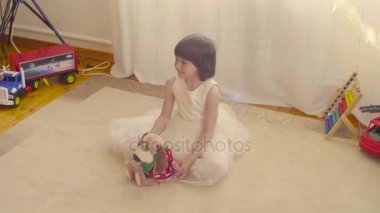 Oyuncak köpek katta oturan bir kızla