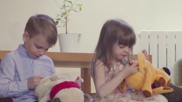 Дівчинка і хлопчик відкривають іграшки — стокове відео
