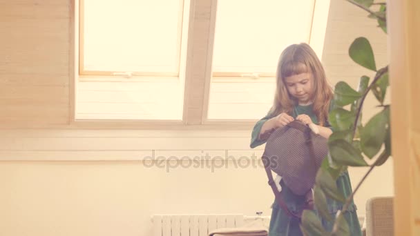 Девушка пытается открыть сумку с игрушками — стоковое видео