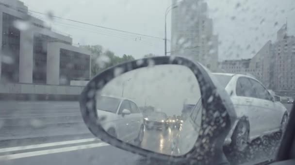 Blick in den Rückspiegel eines Autos auf der Stadtstraße. — Stockvideo