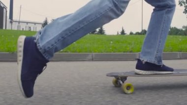 Genç adamın longboard üzerinde binme ayaklar