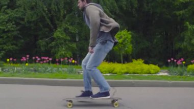 Genç adam longboard üzerinde sürme