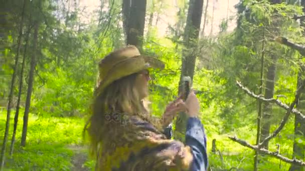 Mujer joven en el bosque tomando fotos — Vídeos de Stock