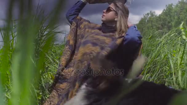 Νεαρή γυναίκα και ένα σκυλί στο γρασίδι — Αρχείο Βίντεο