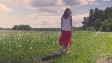 Çayır üzerinde yürüyen genç kadın