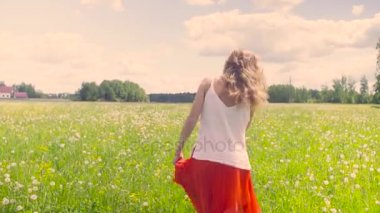 Çayır üzerinde yürüyen genç kadın