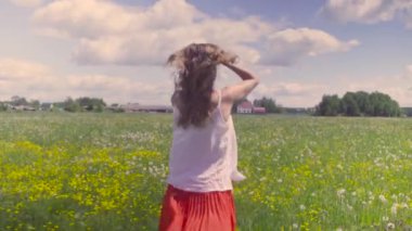 Çayır üzerinde yürüyen genç kadın