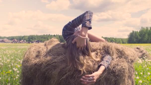 Young woman laying on haystack at summer — Stock Video