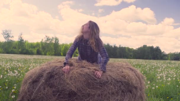 Jonge vrouw springen op de hooiberg — Stockvideo