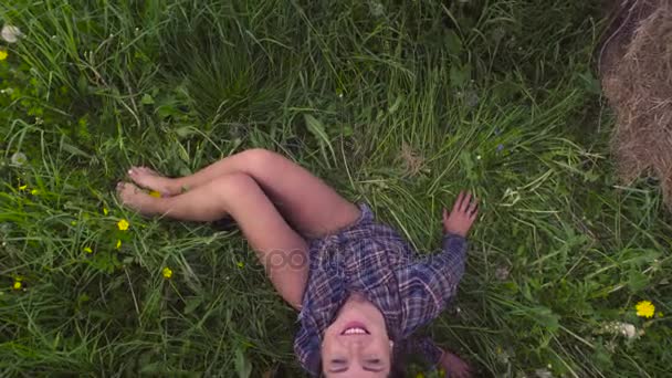 Νεαρή γυναίκα που κάθεται στο γρασίδι στο καλοκαίρι — Αρχείο Βίντεο