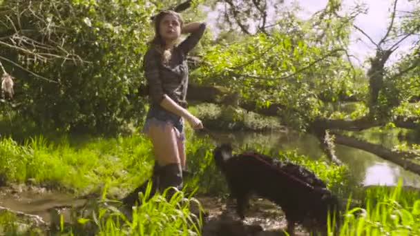 Jeune femme avec un chien qui vient à la rivière — Video