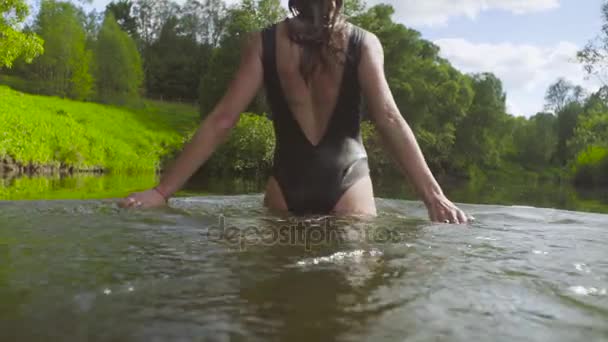 Une jeune femme se baignant dans une rivière forestière — Video