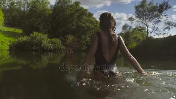 Молода жінка купається в лісовій річці — стокове відео