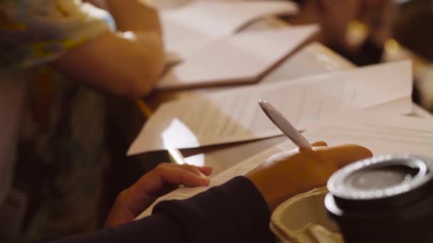 Ręce kobiet pisanie czegoś na papierze — Wideo stockowe