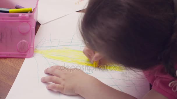 Маленькая девочка рисует за столом — стоковое видео