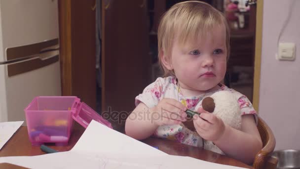 Lilla baby flicka ritning på en tabell — Stockvideo