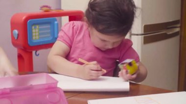 İki küçük kız bir masada çizim