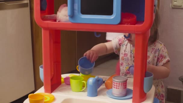 Две сестры играют на игрушечной кухне — стоковое видео