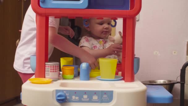 Dos hermanas jugando en la cocina de juguete — Vídeo de stock