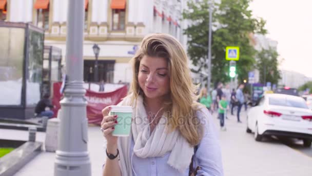 Портрет молодой женщины, идущей с бумажной чашкой — стоковое видео