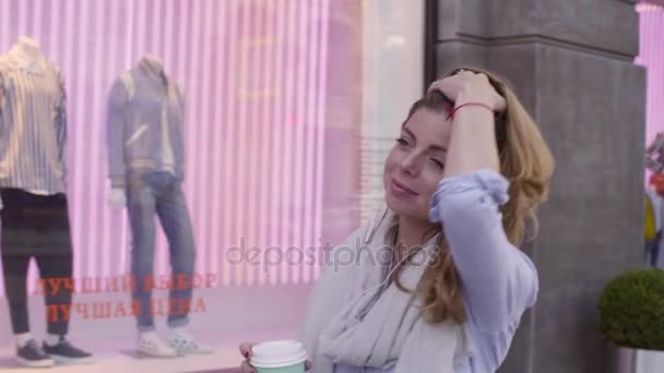 Retrato de mujer joven caminando con taza de papel — Vídeo de stock