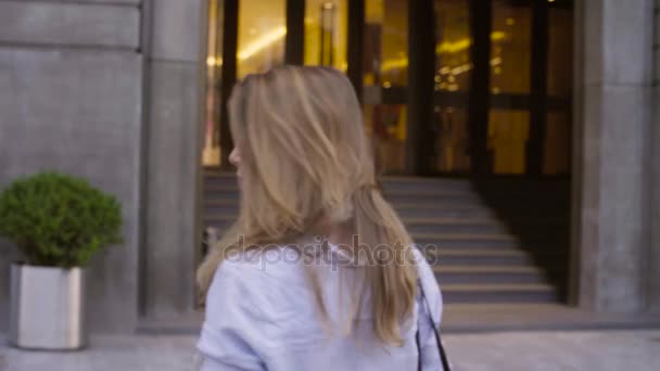 Retrato de mujer joven entrando en la puerta de cristal — Vídeo de stock