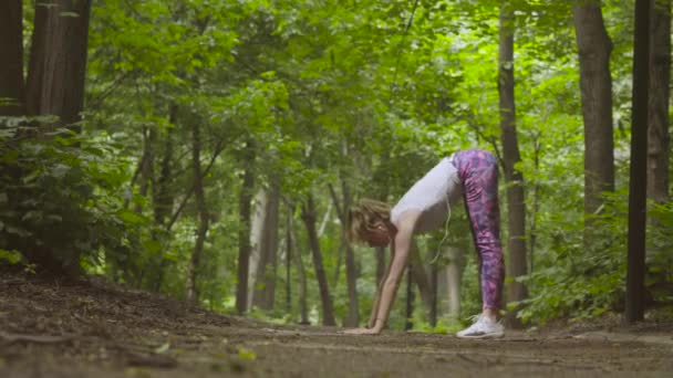 Ung kvinna som tränar yoga i parken — Stockvideo