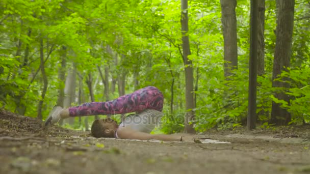 Wanita muda melakukan latihan yoga di taman — Stok Video