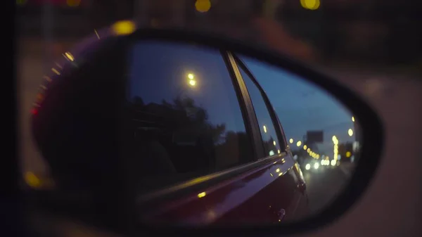 Defocused city lights at night in rearview mirror — Stock Photo, Image