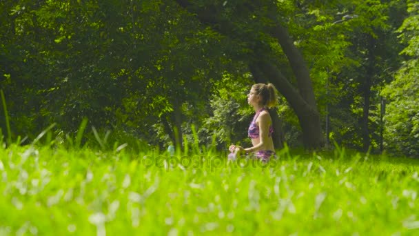 Junge Frau meditiert im Park — Stockvideo