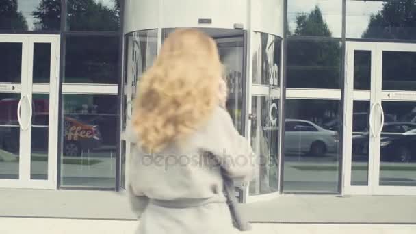 Een jonge vrouw lopen in de deur van de winkel — Stockvideo