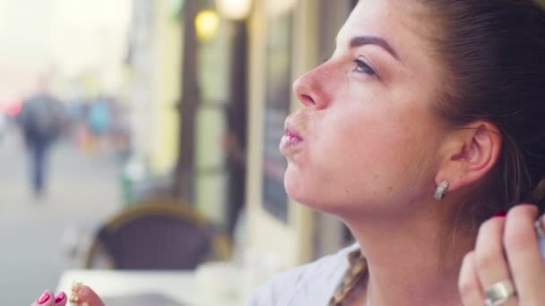 Portret van een jonge vrouw eten cookie — Stockvideo