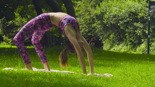 Fiatal nő csinál jóga gyakorlatok a parkban — Stock Fotó