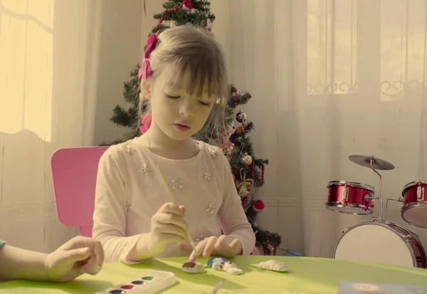 Dívka u vánoční strom malba keramické hračky — Stock fotografie