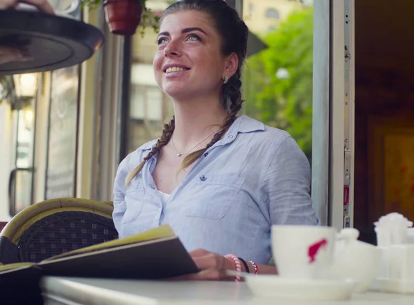 Портрет молодої жінки, що читає меню в кафе — стокове фото