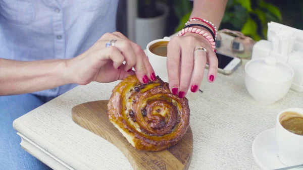 Weibliche Hände teilen ein Stück Plätzchen — Stockfoto