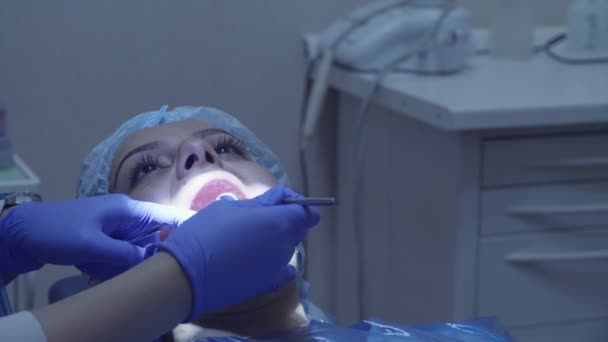 Tandläkare cheking kvinnans tänder med spegel — Stockvideo