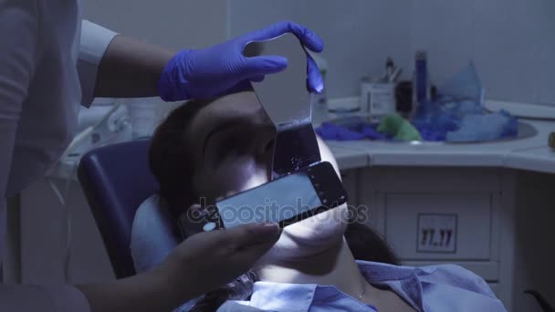 O dentista atirando os dentes dos pacientes no espelho — Vídeo de Stock