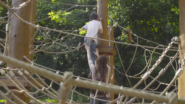 Um rapaz a subir num parque infantil — Vídeo de Stock