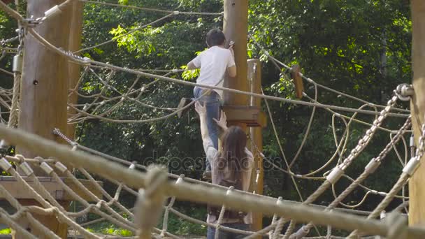 Een jongen klimmen op een speeltoestellen — Stockvideo