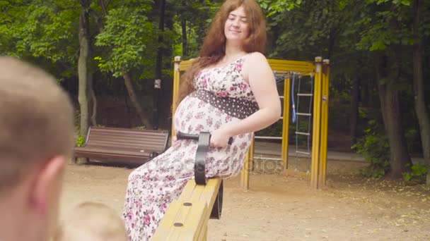Parents heureux avec bébé fille balançant sur une balançoire — Video