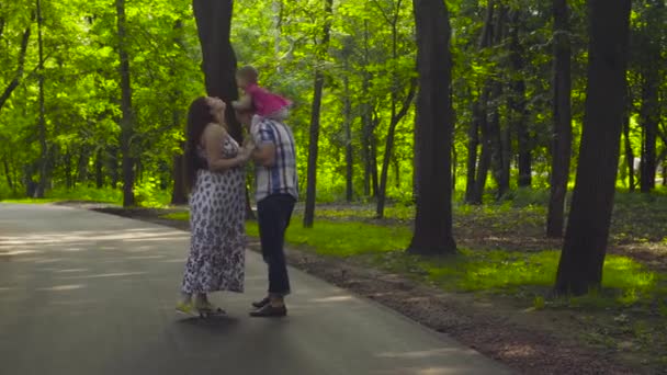 Pais felizes com bebê menina andando em um parque — Vídeo de Stock