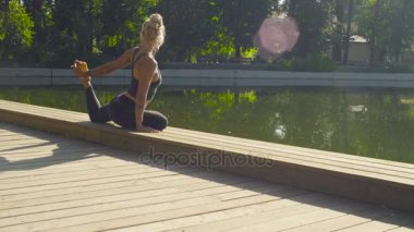 Parkta yoga egzersizi yapan genç bir kadın.