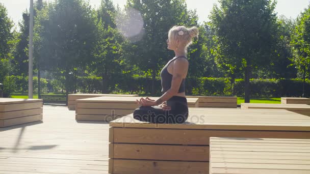 Mujer joven meditando en el parque — Vídeos de Stock