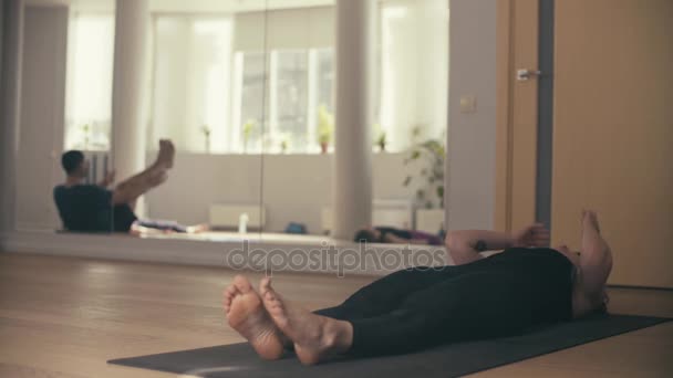 En ung kvinna som utför yoga-asanas i hallen. — Stockvideo