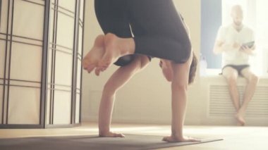 Genç bir kadın Yoga-asanas koridorda gerçekleştirme.