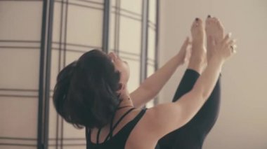 Genç bir kadın Yoga-asanas koridorda gerçekleştirme.