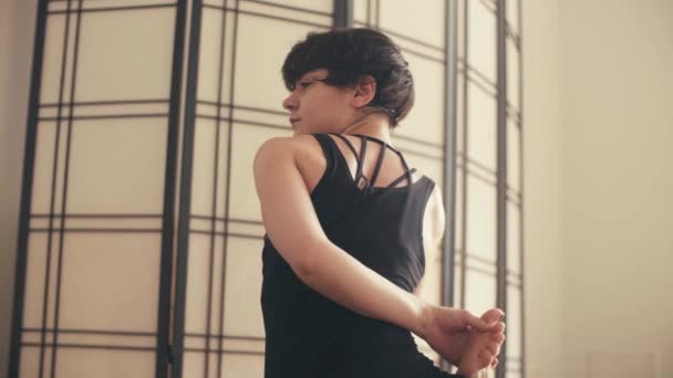 A young woman performing yoga-asanas in the hall. — Stock Video